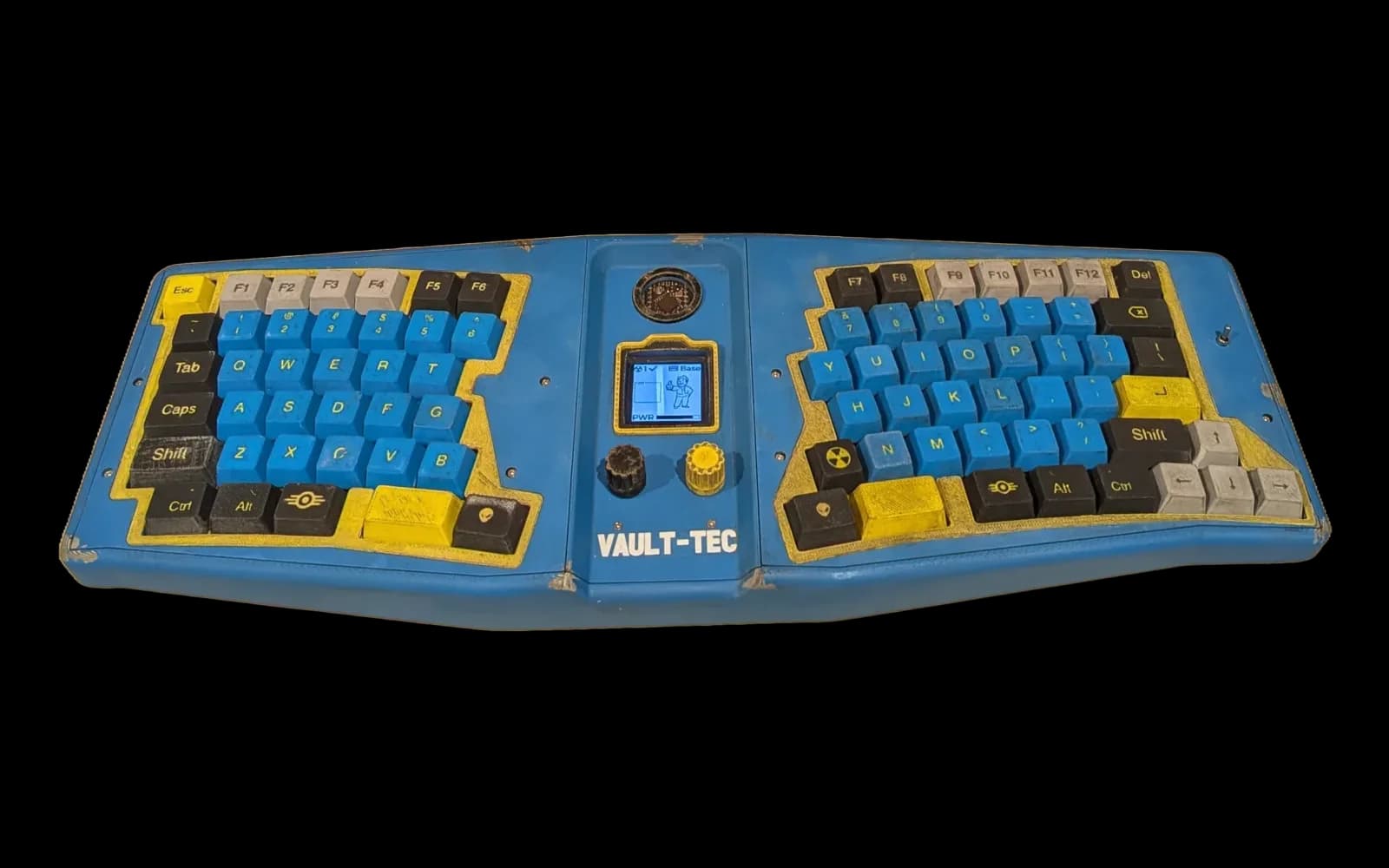 Vault 84: a weathered blue ergonomic keyboard with an OLED screen and two knobs in its centre console